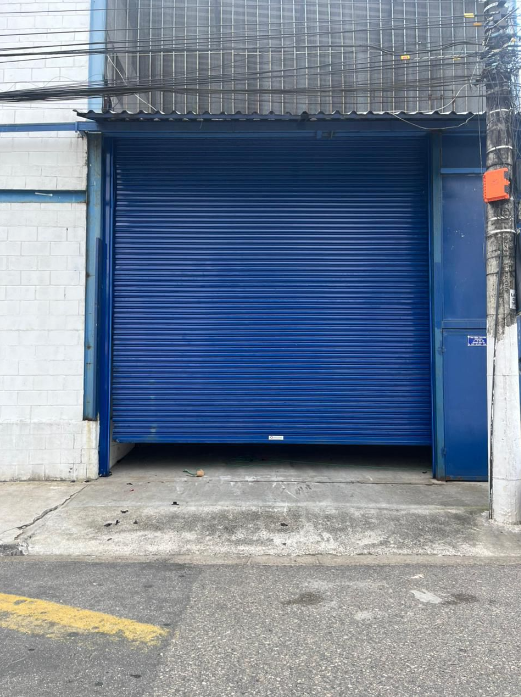Porta de aço automática azul instalada em galpão